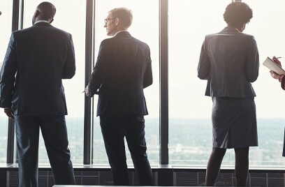 Employees standing at window discussing work