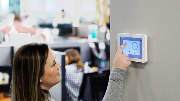 Um homem escaneando seu dispositivo em um dispositivo de acesso de segurança