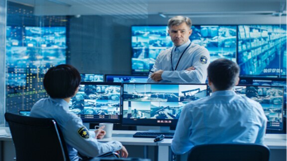 Security staff monitoring multiple screens in a control room