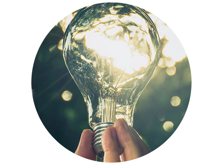 Person holding up a lightbulb with the sun shining through the glass