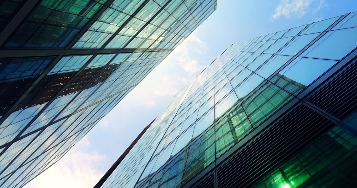Frog's-eye view of multi-storey glass buildings at daytime