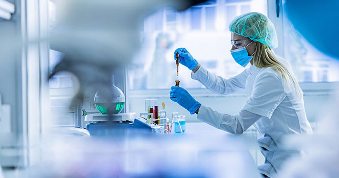 Female researcher in a lab coat working with test tubes in a laboratory