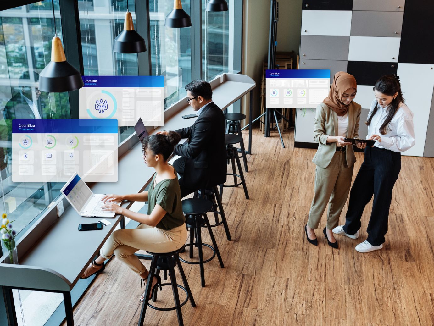 Pessoas sentadas em um balcão e outras em pé atrás, trabalhando