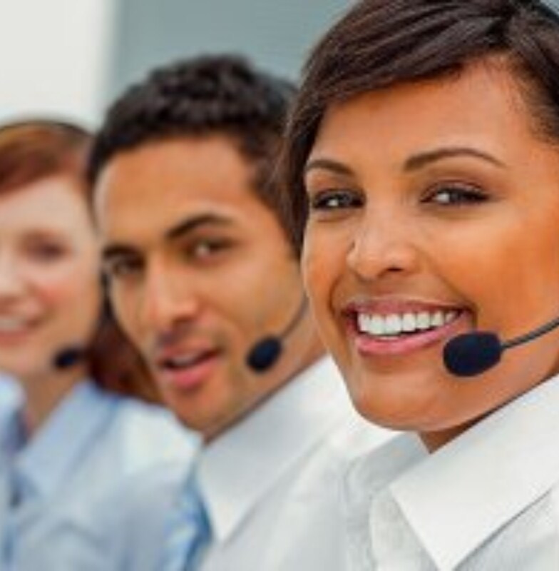 Four people wearing headphones with microphones looking into the camera